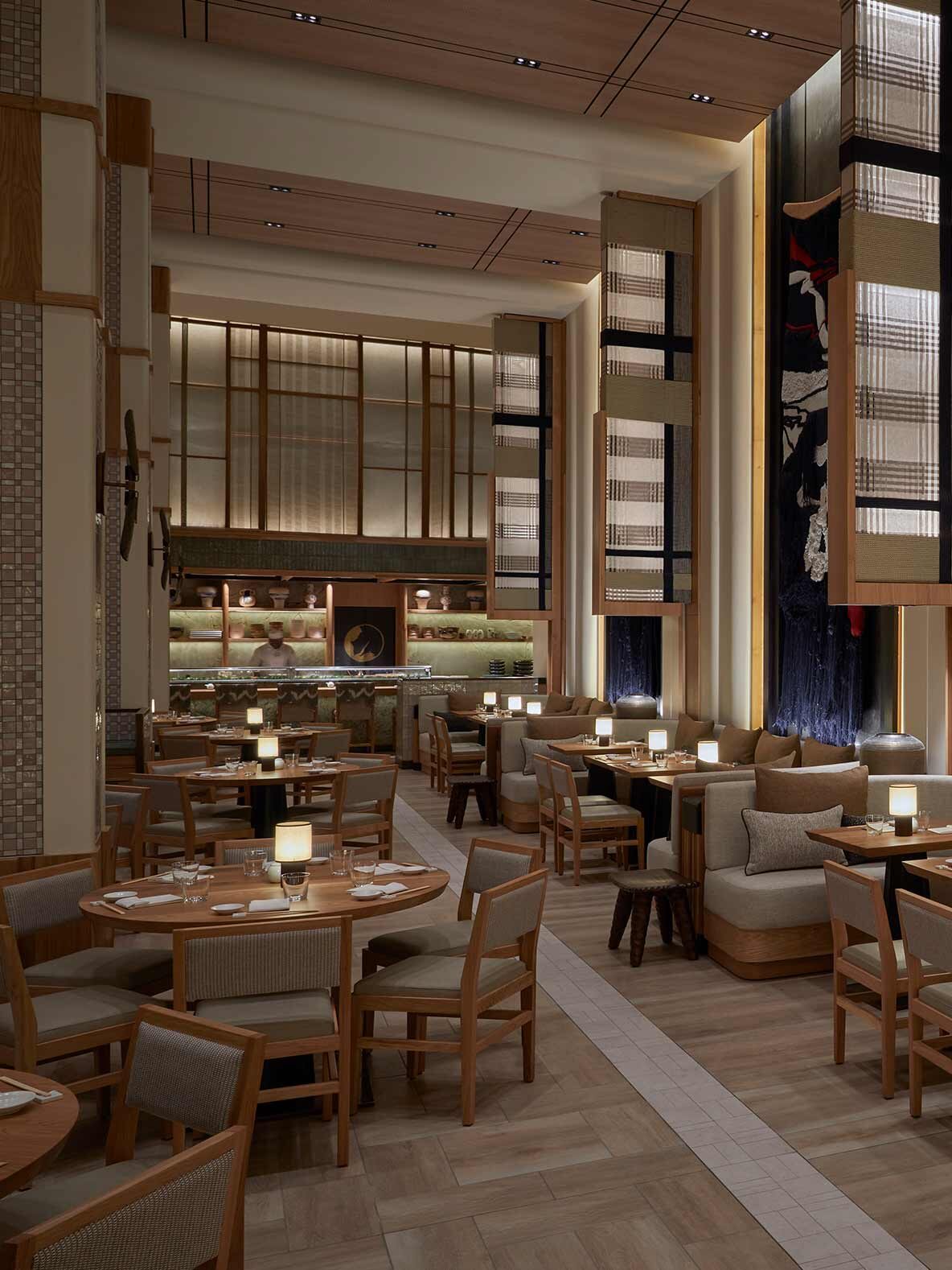 Nobu restaurant at the One&Only hotel with layered fluted plaster pilasters by Plaster Art SA framing a double-volume dining room with wood banquettes and herringbone flooring