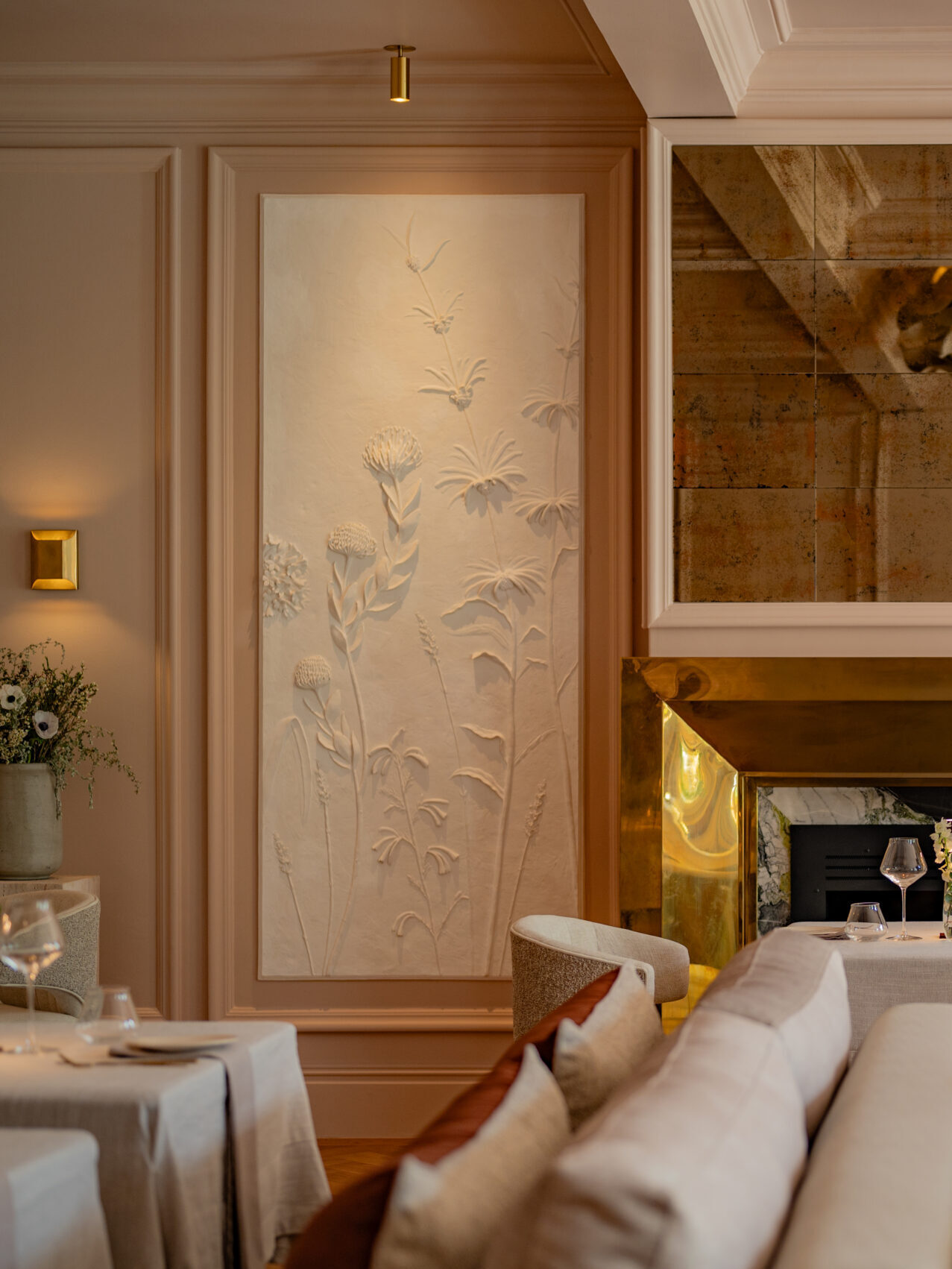 Bloom restaurant with hand-sculpted plaster botanical relief panels by Plaster Art SA, depicting protea and daisy stems framed within the dining room's wall panelling