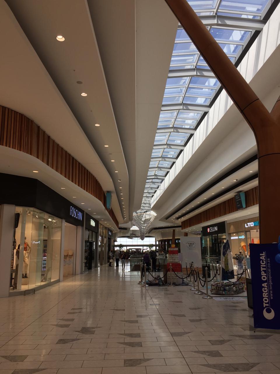 Table Bay Mall shopping concourse with flowing layered ceiling bulkheads, light troughs and skylight detailing by Plaster Art above the retail walkway.